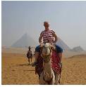 Donna Busha riding a camel near the pyramids in Egypt